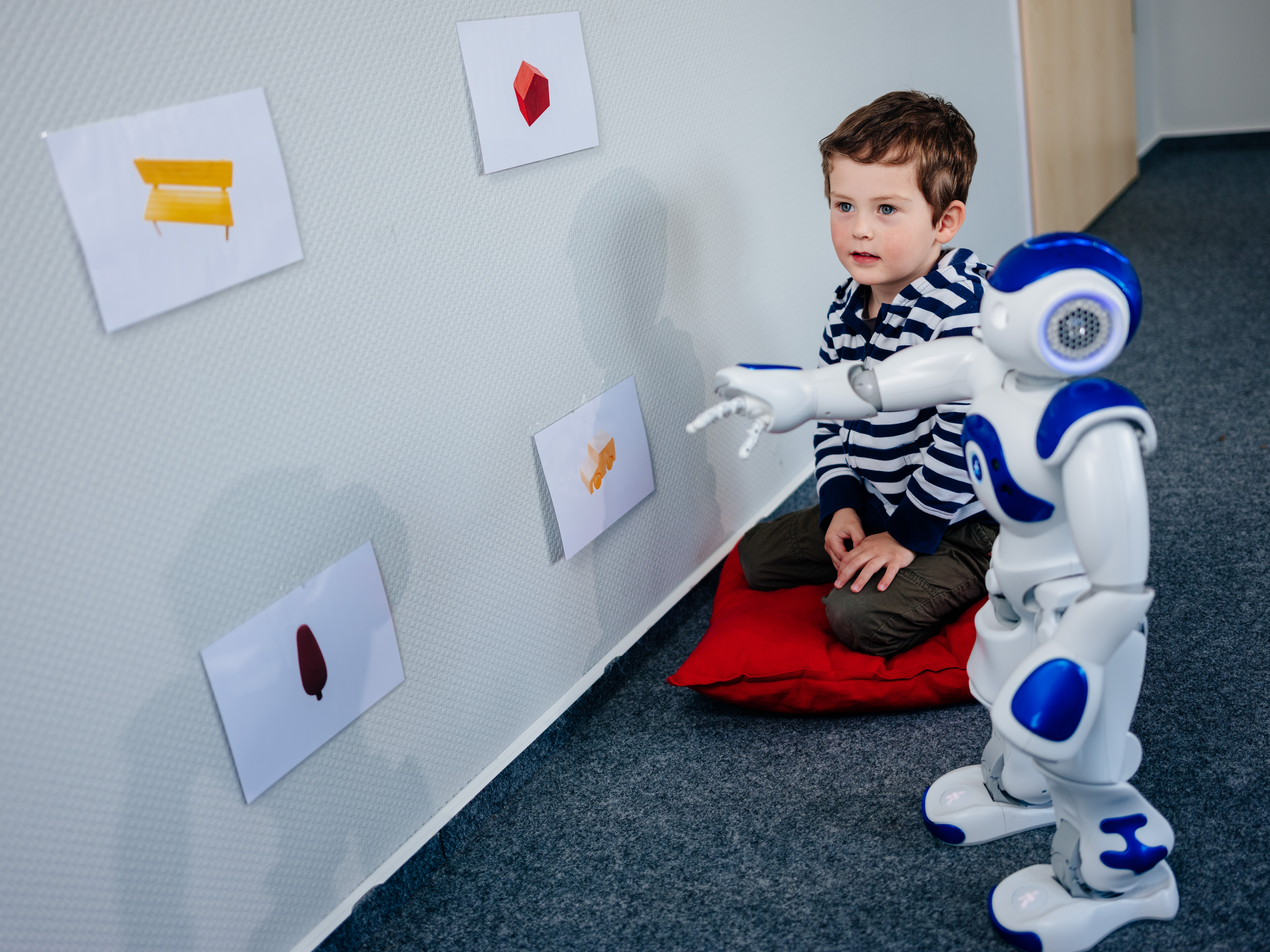Kind hockt Roboter Bilder an Wand